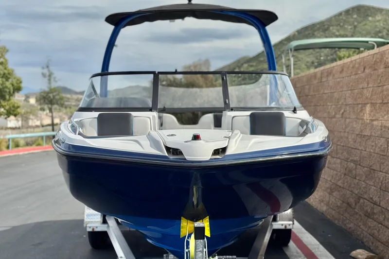 Slide: The Image of 2020 Yamaha Boats AR210 on trailer, parked outdoors with scenic mountain backdrop. - 2