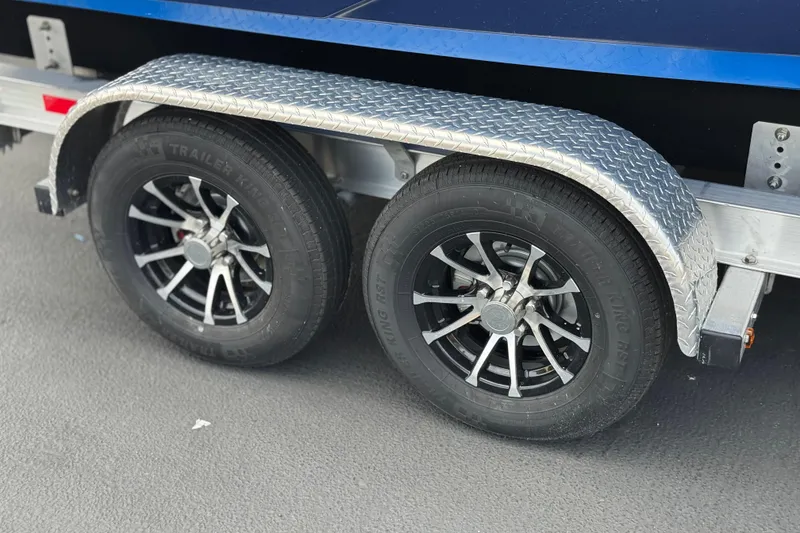 Slide: The Image of Trailer wheels of a 2020 Yamaha Boats AR210, featuring sleek black rims. - 32