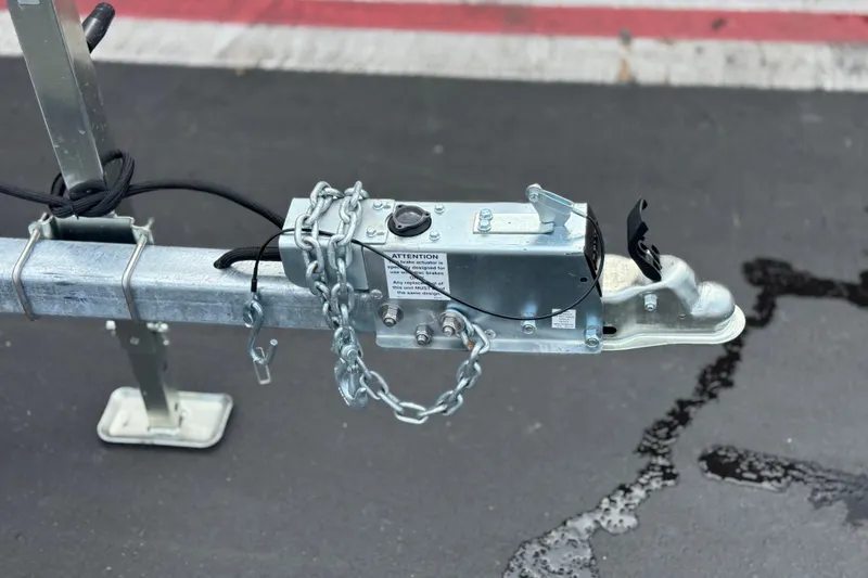 Slide: The Image of Trailer hitch of a 2020 Yamaha Boats AR210, secured with chains on asphalt. - 33