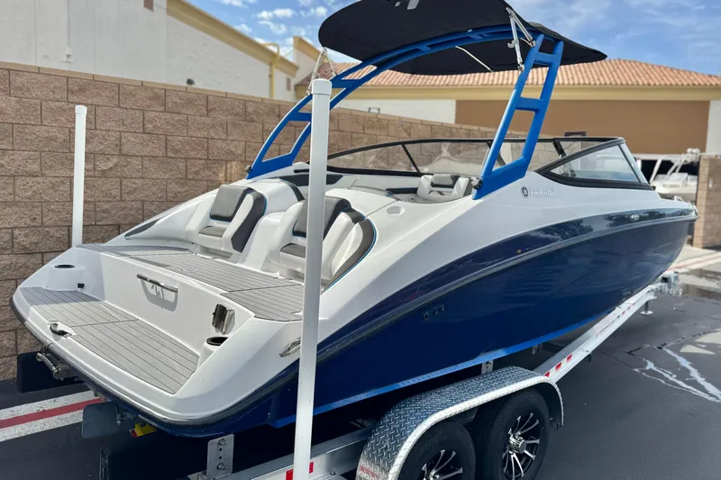 Slide: The Image of 2020 Yamaha Boats AR210 on trailer, blue and white design, parked outdoors. - 5