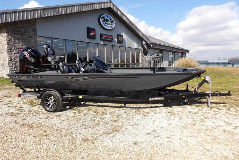 The Image of 2026 Crestliner XFC 189 boat on trailer outside marine center, under blue sky. - 0