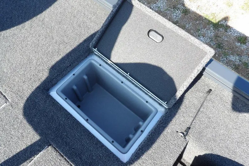 Slide: The Image of Open storage compartment on 2026 Crestliner XFC 189 boat, featuring carpeted interior. - 15