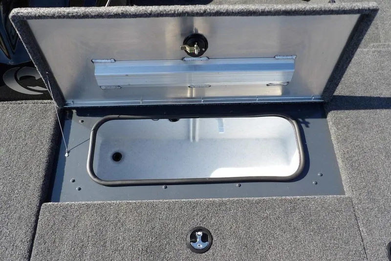 Slide: The Image of Open storage compartment on 2026 Crestliner XFC 189 boat, featuring carpeted interior. - 23