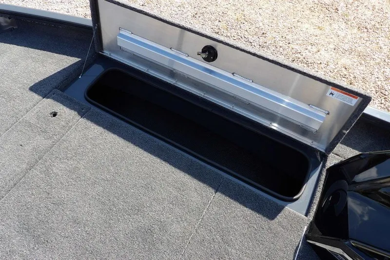 Slide: The Image of Open storage compartment in 2026 Crestliner XFC 189 boat, featuring carpeted interior. - 29