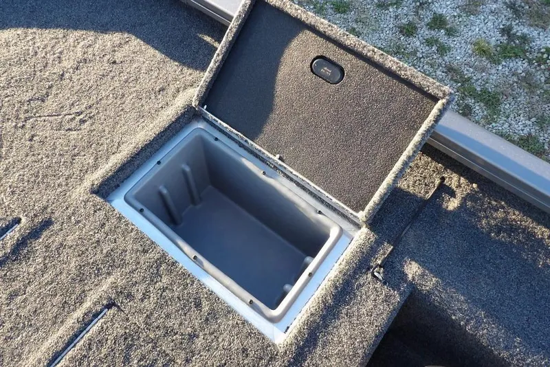 Slide: The Image of Open storage compartment on 2026 Crestliner XFC 189 boat, featuring carpeted interior. - 12