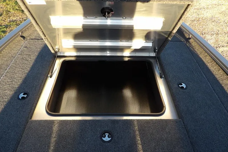 Slide: The Image of Open storage compartment in 2026 Crestliner XFC 189 boat, featuring carpeted interior. - 27