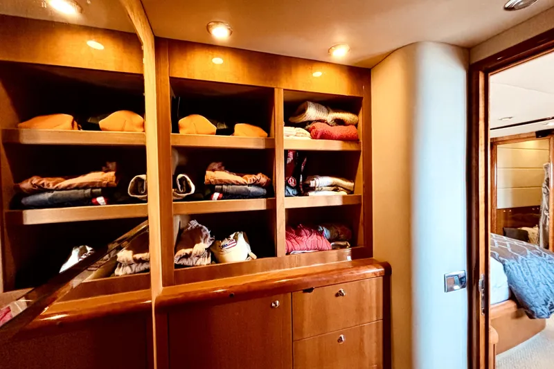 Slide: The Image of Luxurious wooden closet with neatly organized clothes on a 2005 Sunseeker 75 Yacht. - 19