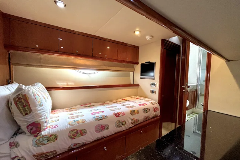 Slide: The Image of Luxurious 2005 Sunseeker 75 Yacht cabin with single bed, TV, and ensuite bathroom. - 32
