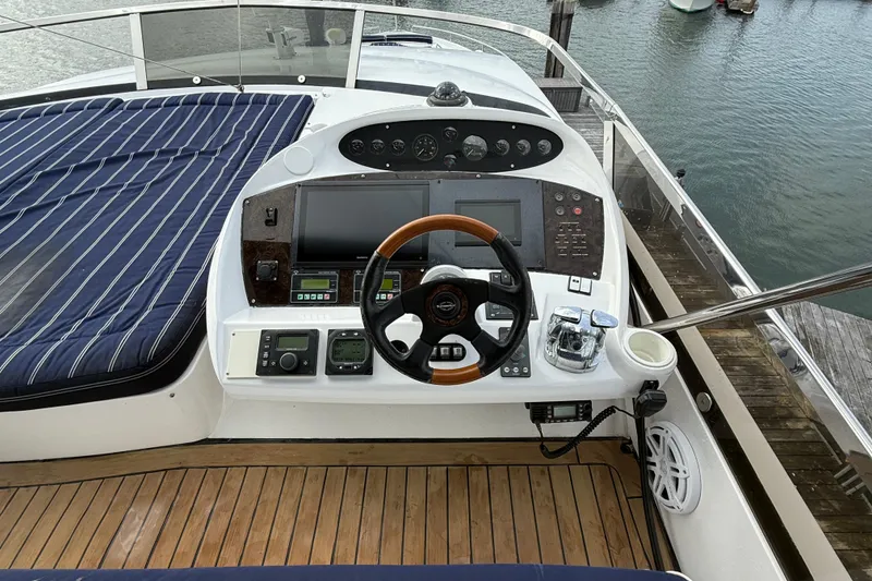 Slide: The Image of Cockpit of 2005 Sunseeker 75 Yacht with wooden steering wheel and navigation controls. - 35