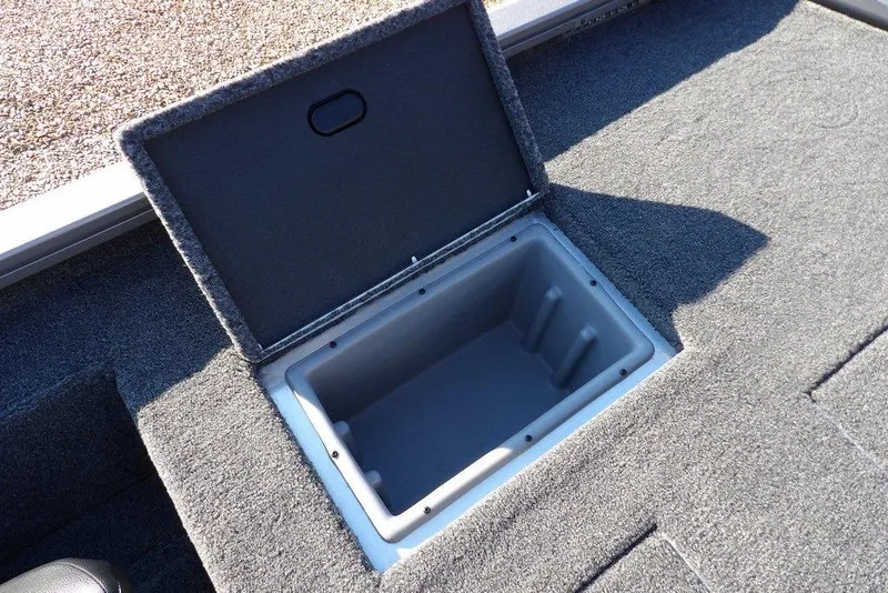 Slide: The Image of Open storage compartment in 2026 Crestliner XFC 189 boat, featuring carpeted interior. - 11