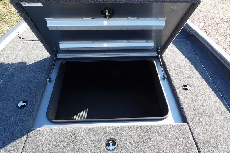Slide: The Image of Open storage compartment on 2026 Crestliner XFC 189 boat, featuring carpeted interior. - 25