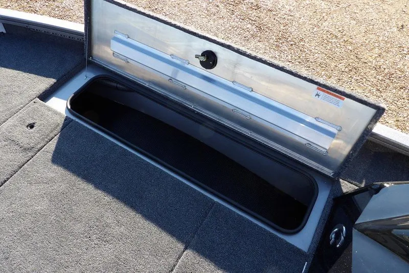 Slide: The Image of Open storage compartment in 2026 Crestliner XFC 189 boat, featuring carpeted interior. - 31