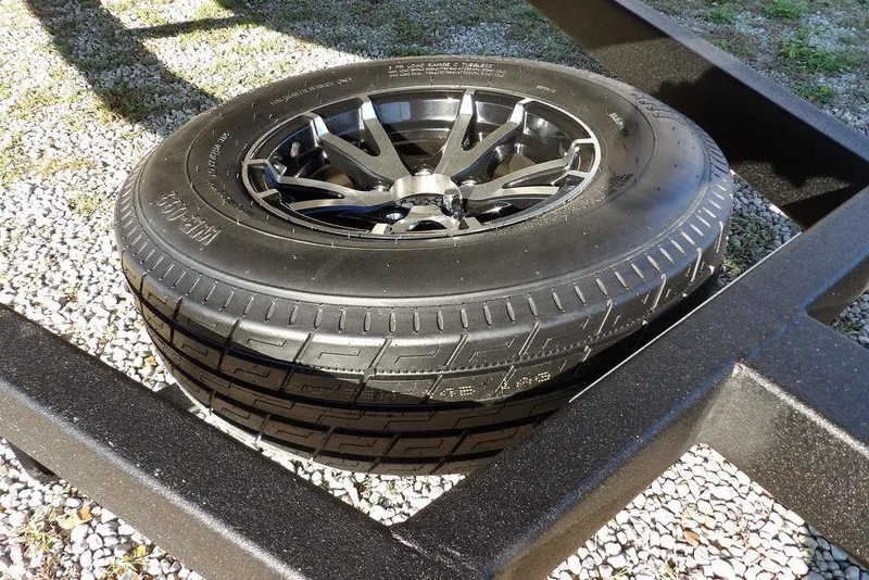 Slide: The Image of Spare tire on Crestliner XFC 189 trailer, 2026 model, resting on gravel. - 34