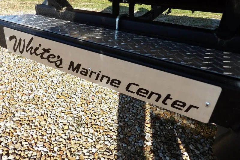 Slide: The Image of White's Marine Center sign on Crestliner XFC 189, 2026 model, on gravel surface. - 36