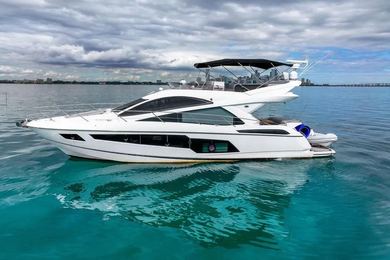 Slide: The Image of 2016 Sunseeker Manhattan 55 yacht on calm blue water under cloudy sky. - 1