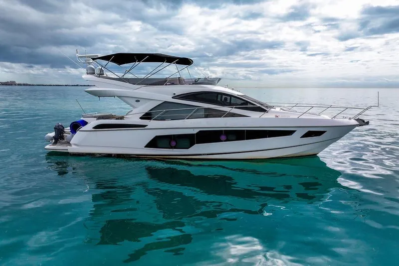 Slide: The Image of 2016 Sunseeker Manhattan 55 yacht on calm turquoise waters under cloudy sky. - 2