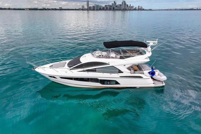 Slide: The Image of 2016 Sunseeker Manhattan 55 yacht on calm blue waters with city skyline. - 6