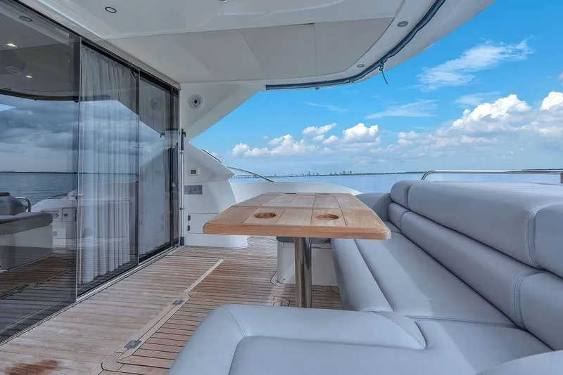 Slide: The Image of Luxurious Sunseeker Manhattan 55 yacht deck with seating, table, and ocean view. - 63