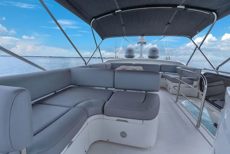 Slide: The Image of 2016 Sunseeker Manhattan 55 yacht with spacious seating under a canopy on calm waters. - 69