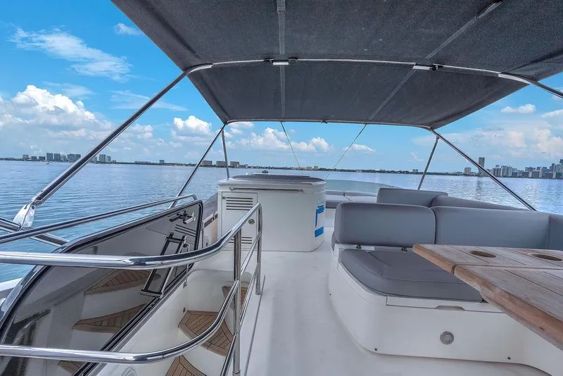 Slide: The Image of Luxurious 2016 Sunseeker Manhattan 55 yacht deck with seating, overlooking calm waters and city skyline. - 72