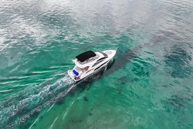 Slide: The Image of 2016 Sunseeker Manhattan 55 yacht cruising on clear turquoise waters. - 9