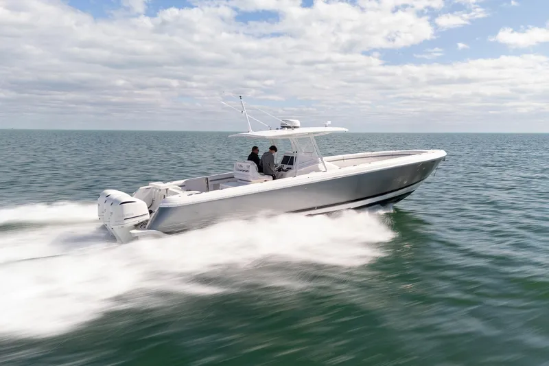 Slide: The Image of 2015 Intrepid 400 Center Console speeding on open water under a partly cloudy sky. - 13