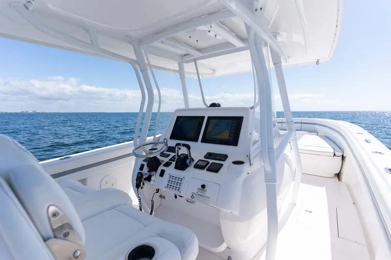 Slide: The Image of 2015 Intrepid 400 Center Console boat interior with navigation screens, steering wheel, and ocean view. - 17