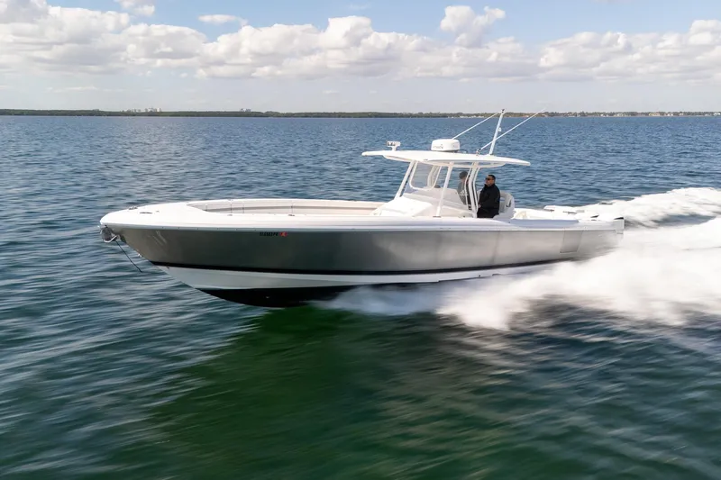 Slide: The Image of 2015 Intrepid 400 Center Console boat cruising on open water under a cloudy sky. - 9