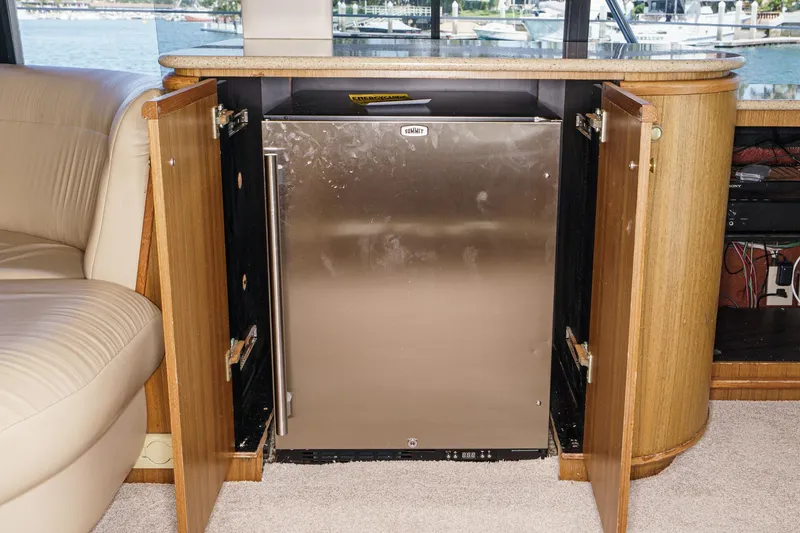 Slide: The Image of Bayliner 5788 Pilot House Motoryacht 2000 interior with stainless steel fridge and wooden cabinetry. - 30