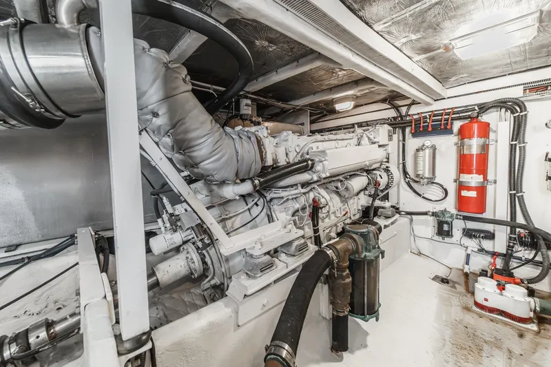 Slide: The Image of Engine room of 2000 Bayliner 5788 Pilot House Motoryacht, featuring machinery and fire extinguisher. - 56