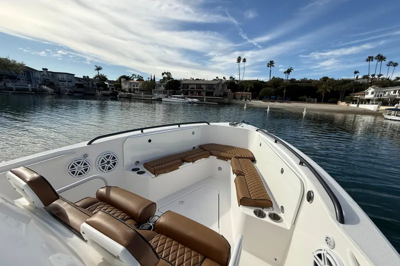 Slide: The Image of 2008 Everglades 290 Center Console boat with brown seating, docked near waterfront homes. - 10