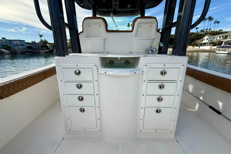 Slide: The Image of 2008 Everglades 290 Center Console boat interior with storage and sink, docked by waterfront homes. - 17