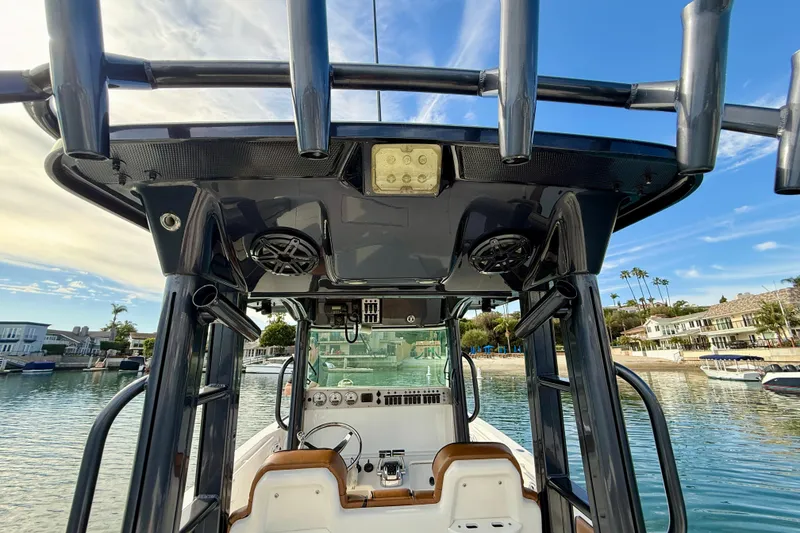 Slide: The Image of 2008 Everglades 290 Center Console boat interior with speakers and control panel, docked by waterfront homes. - 18