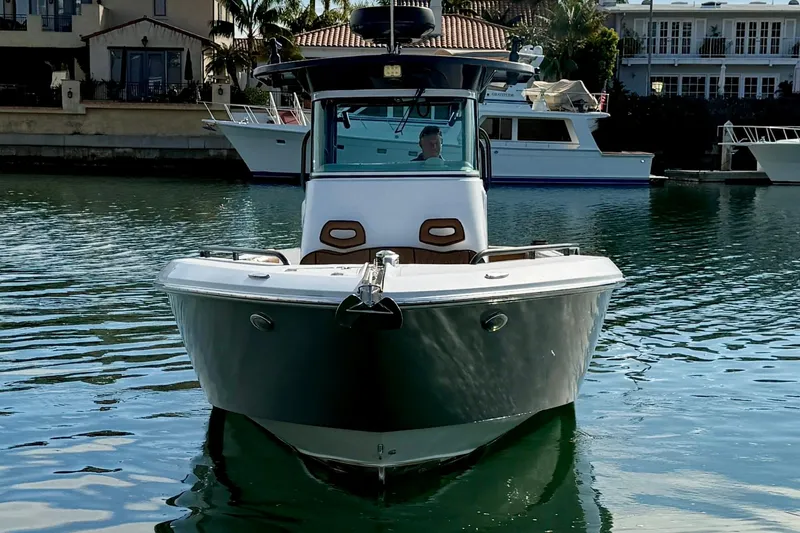Slide: The Image of 2008 Everglades 290 Center Console boat on calm water, docked near waterfront homes. - 3