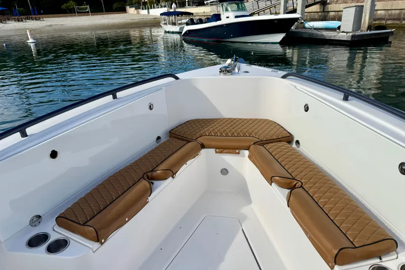 Slide: The Image of 2008 Everglades 290 Center Console boat with tan cushioned seating, docked by the water. - 5
