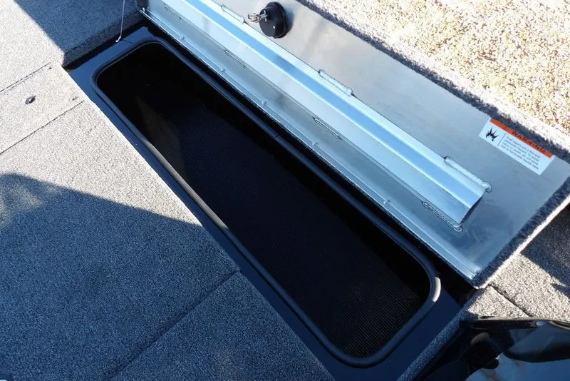 Slide: The Image of Open storage compartment in 2026 Crestliner XFC 189 boat, featuring carpeted interior. - 31