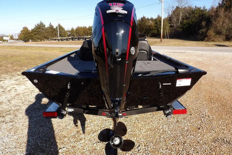 Slide: The Image of 2026 Crestliner XFC 189 boat, rear view with powerful outboard motor, parked on gravel. - 5