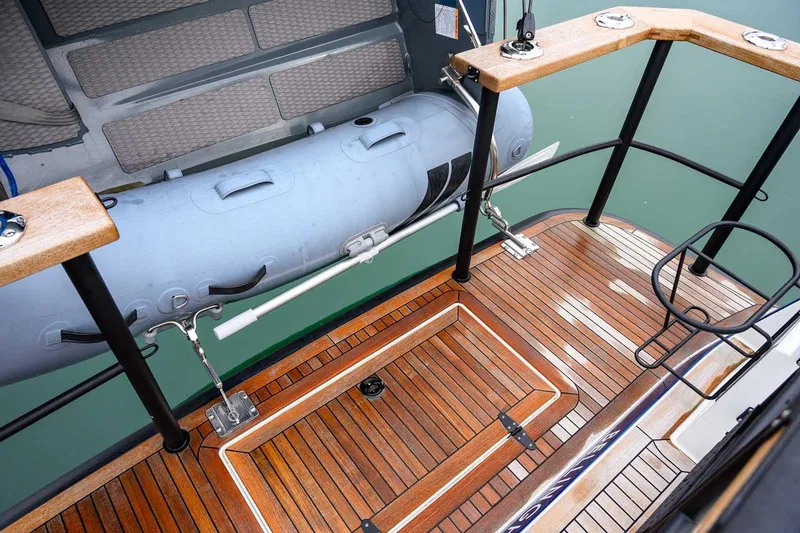Slide: The Image of 2024 Targa 27.2 boat deck with wooden flooring and inflatable dinghy. - 27