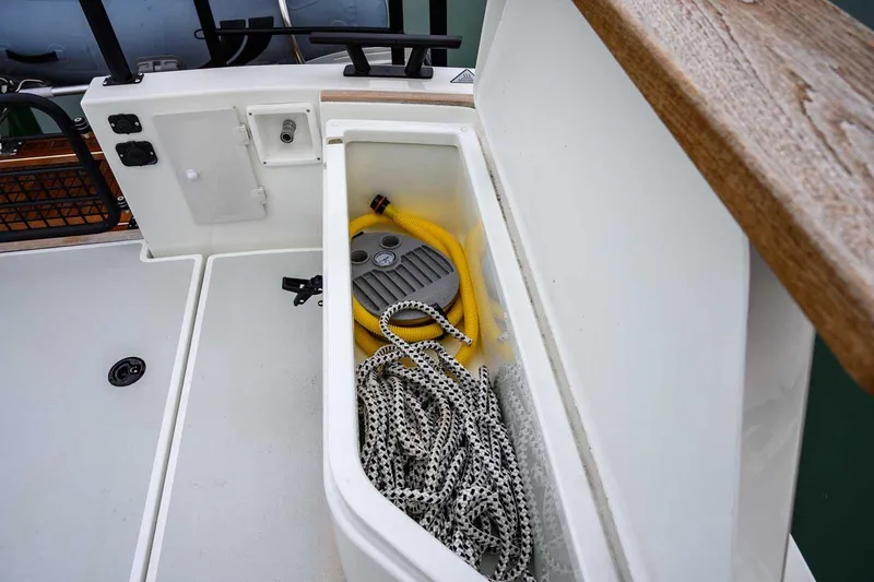 Slide: The Image of Storage compartment on 2024 Targa 27.2 boat with rope and hose. - 31