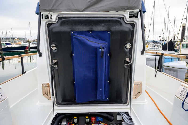 Slide: The Image of 2024 Targa 27.2 boat interior with blue storage compartment, docked at marina. - 33