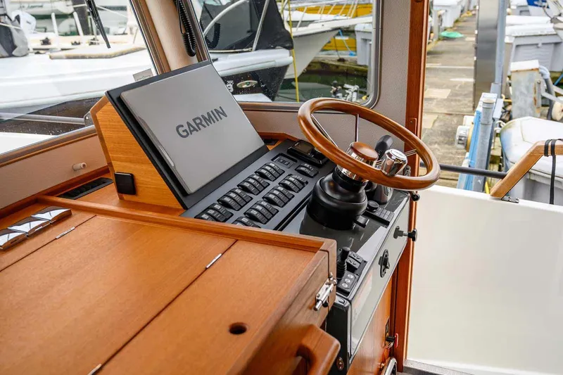 Slide: The Image of 2024 Targa 27.2 boat helm with Garmin navigation and wooden steering wheel. - 40