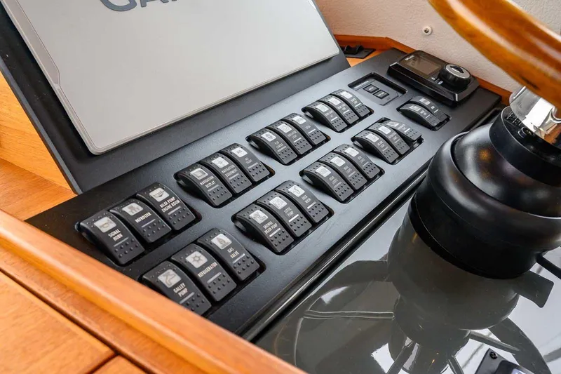 Slide: The Image of Control panel of 2024 Targa 27.2 boat with multiple switches and steering wheel. - 44