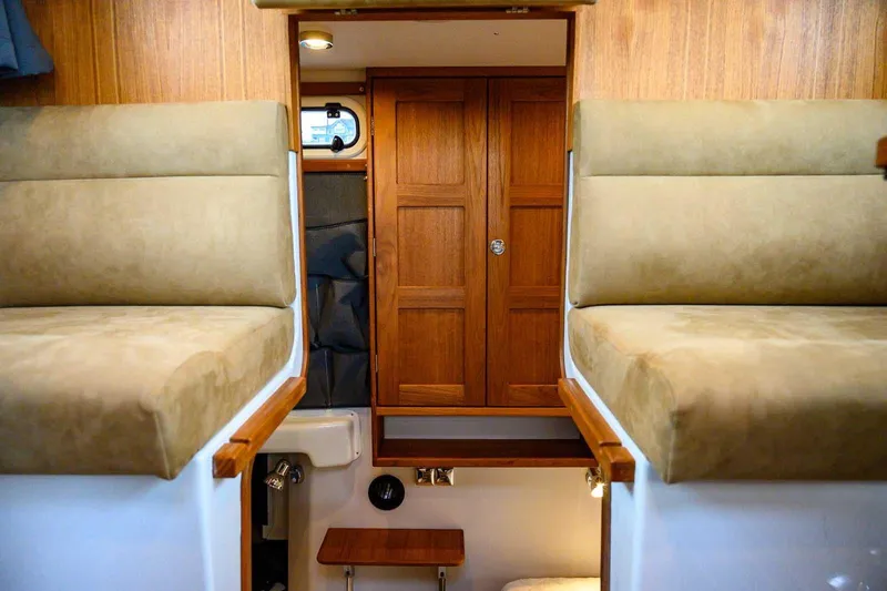 Slide: The Image of Interior of 2024 Targa 27.2 boat with wooden cabinetry and cushioned seating. - 49