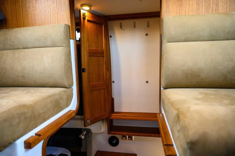 Slide: The Image of 2024 Targa 27.2 interior with wooden cabinetry and beige seating. - 50
