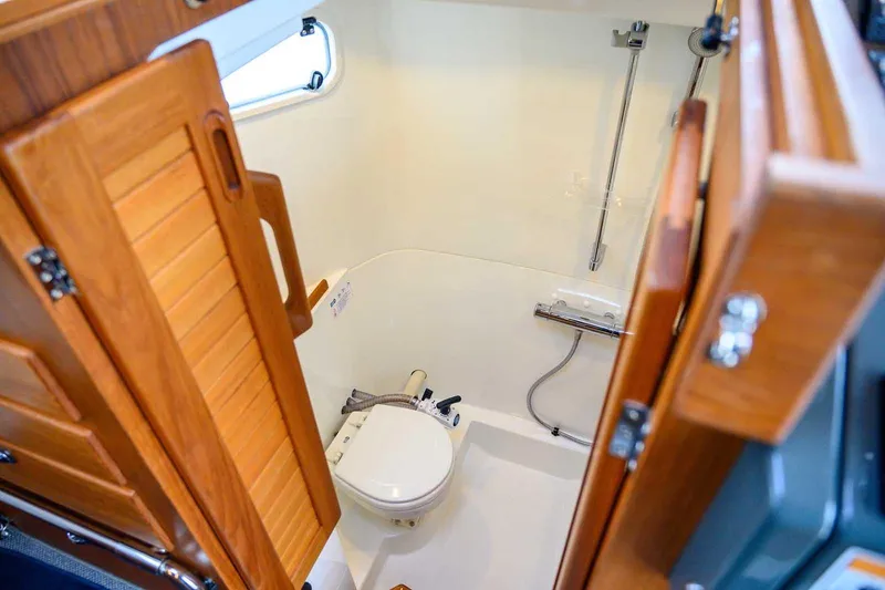 Slide: The Image of 2024 Targa 27.2 boat bathroom with wooden door and compact shower area. - 52