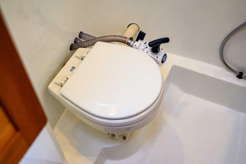 Slide: The Image of 2024 Targa 27.2 boat bathroom with compact marine toilet and manual pump. - 53