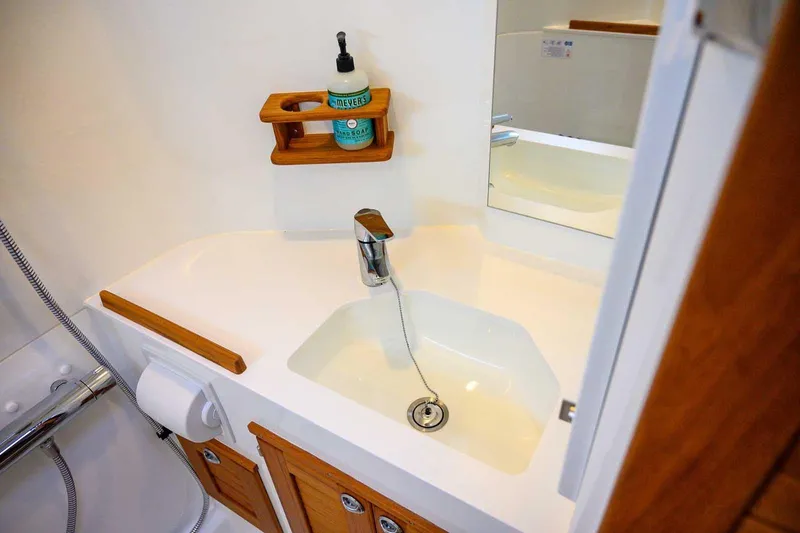 Slide: The Image of Modern bathroom sink in 2024 Targa 27.2 boat, featuring wooden accents and soap dispenser. - 54