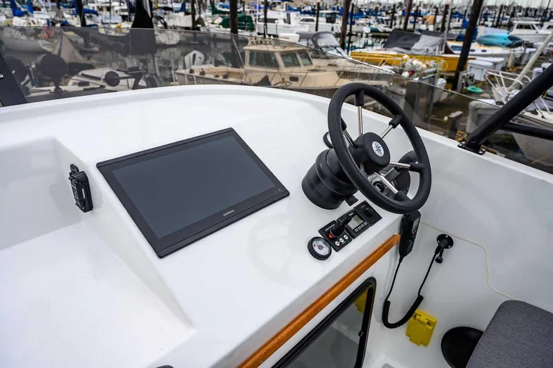 Slide: The Image of 2024 Targa 27.2 boat helm with steering wheel and navigation display at marina. - 9