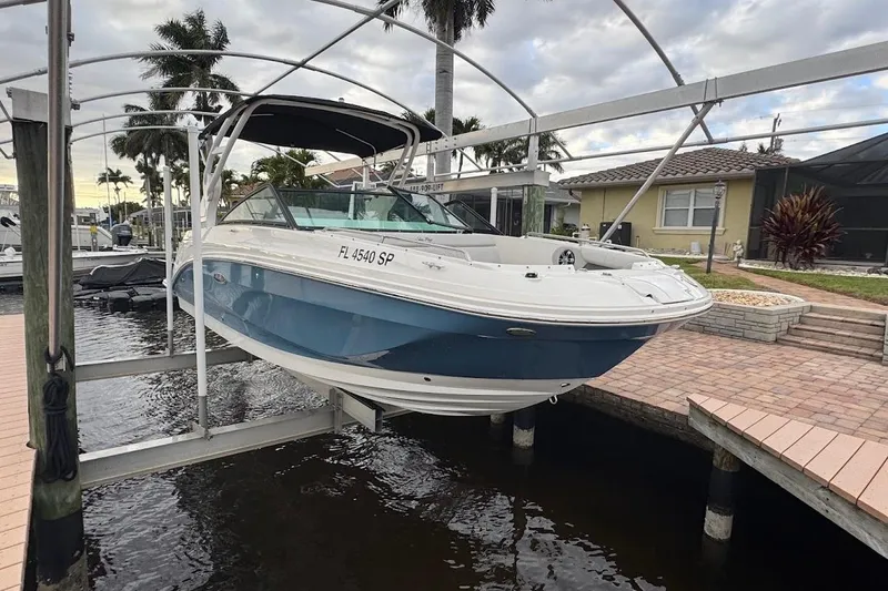 The Image of 2020 Sea Ray SDX 250 Outboard boat on calm water near waterfront homes. - 0