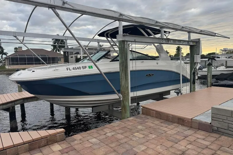 Slide: The Image of 2020 Sea Ray SDX 250 Outboard boat on a sunny waterfront. - 1